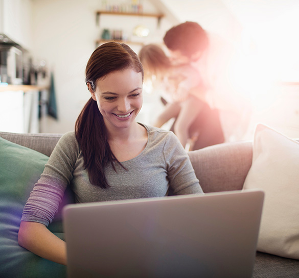 Lady using a laptop computer in her living room with family