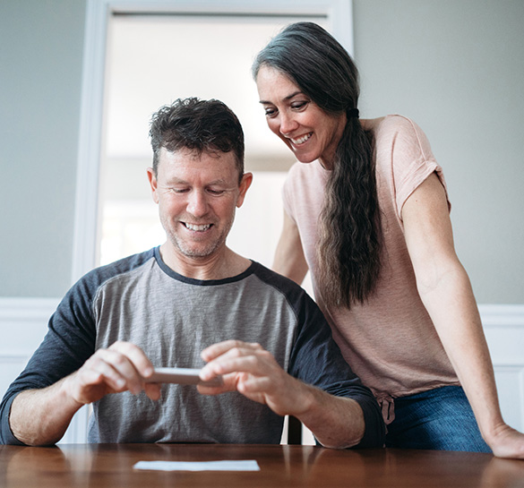 Couple using a smartphone to make a deposit deposit