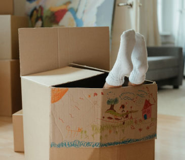 Lady playfully inside a moving box in a new home